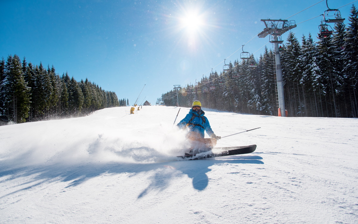 Tanvaldský Špičák in Czech Republic - a person skiing down a hill on a sunny day.