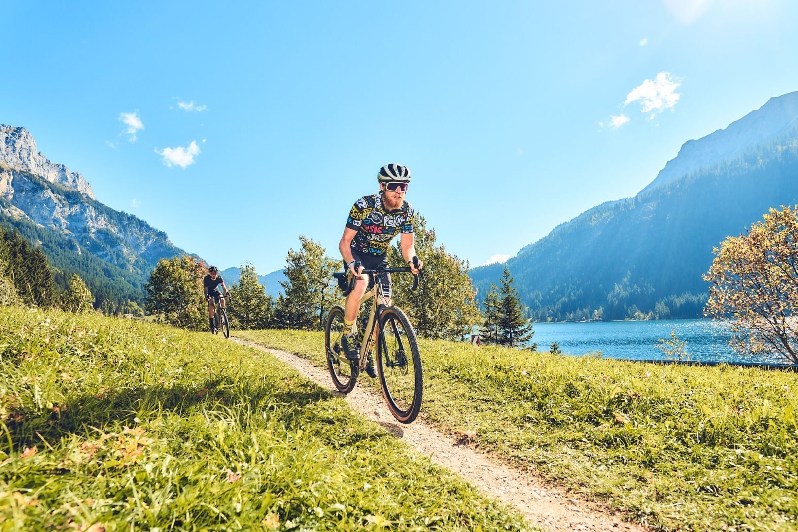 Krinnenalpe in Austria - a man riding a mountain bike on a trail near a lake.