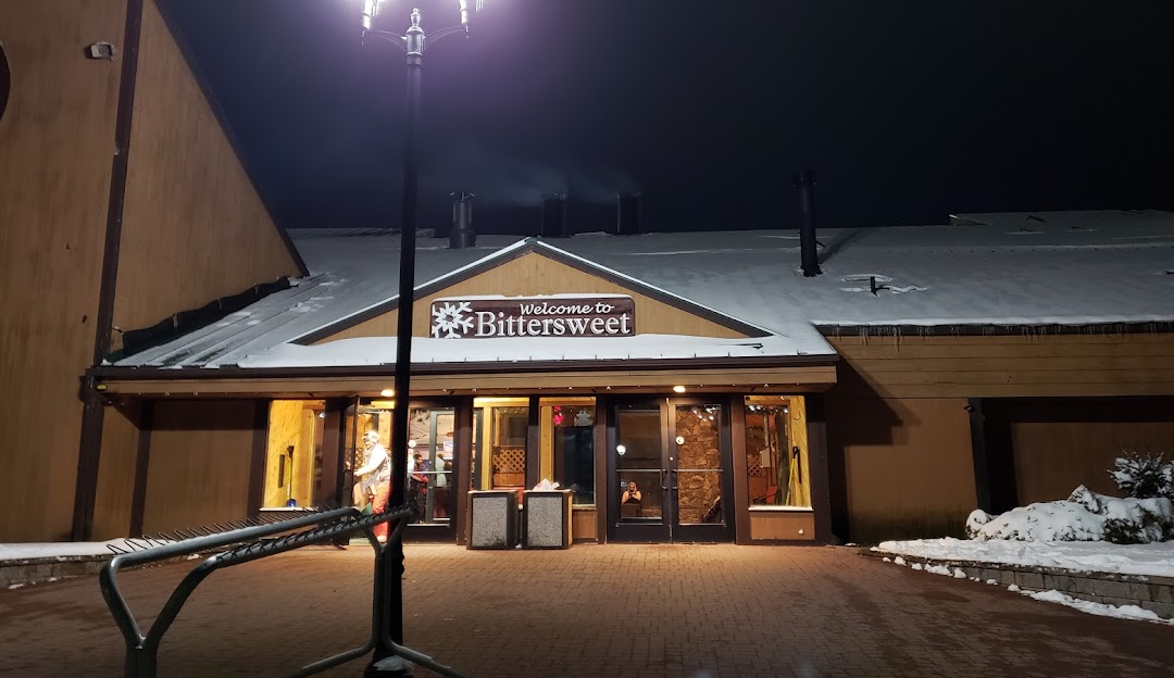 Winter sports enthusiasts enjoying a day at the Bittersweet ski resort in Otsego, Michigan, featuring a chalet in a scenic snowy landscape.