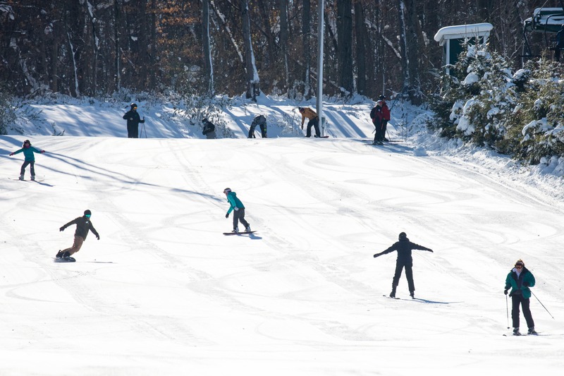 Winter sports scene at Bittersweet in Otsego, Michigan, showcasing a group of individuals engaging in skiing activities.