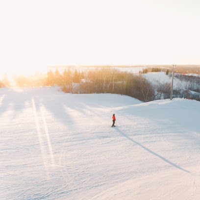 A winter sports scene at Asessippi in Inglis Manitoba Canada featuring a skier enjoying the beautiful winter scenery at the ski resort.