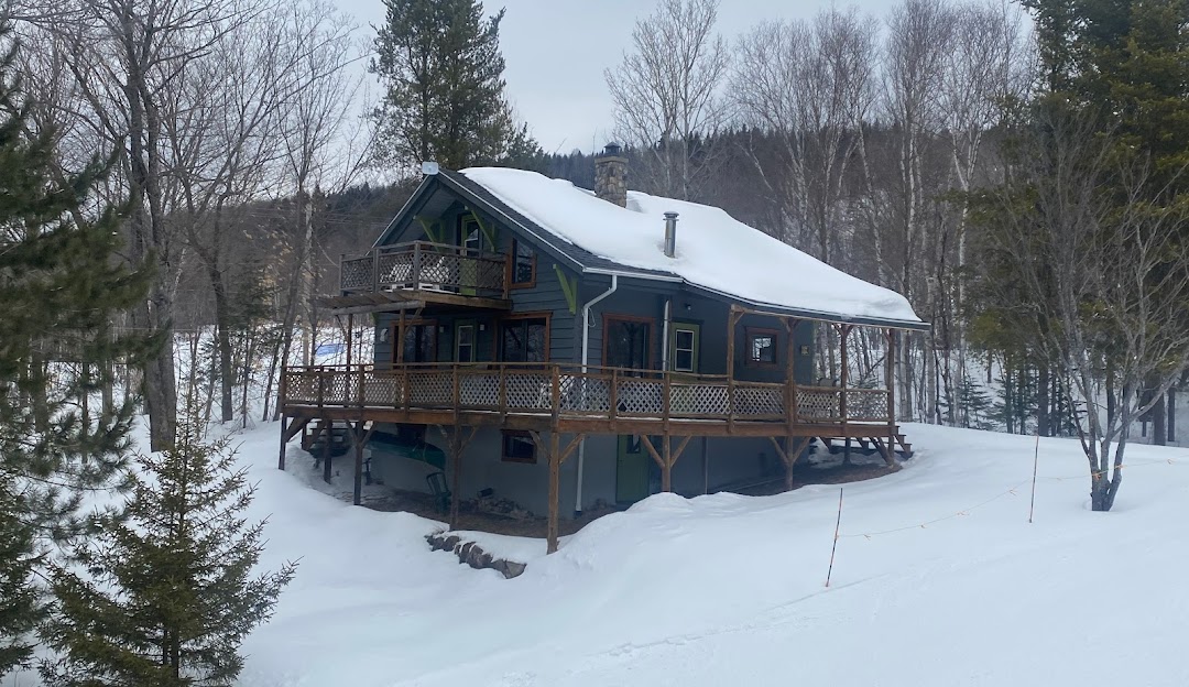View of Ski Garceau in Quebec, Canada showing a cozy lodge, prominent ski resort facilities, athletes engaging in winter sports, a charming challet, and a breathtaking winter landscape.