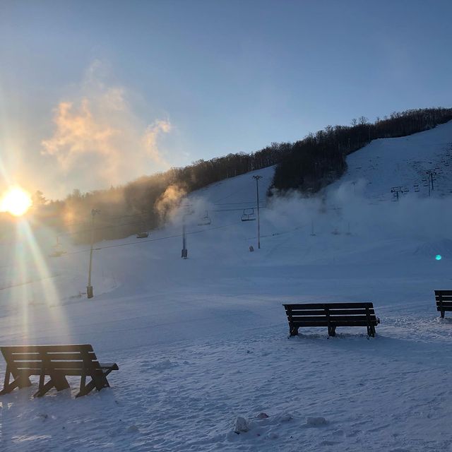 Winter scene at Ski Chantecler in Sainte-Adèle, Quebec featuring a bustling ski resort with skiers enjoying the powdery slopes, surrounded by a stunning snow-covered landscape.