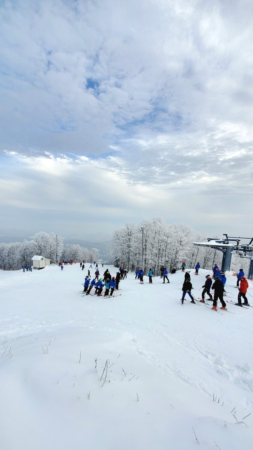 Winter scene at Ski Chantecler in Quebec, Canada, featuring skiers on a lift ascending the snow-covered mountain at a popular ski resort.