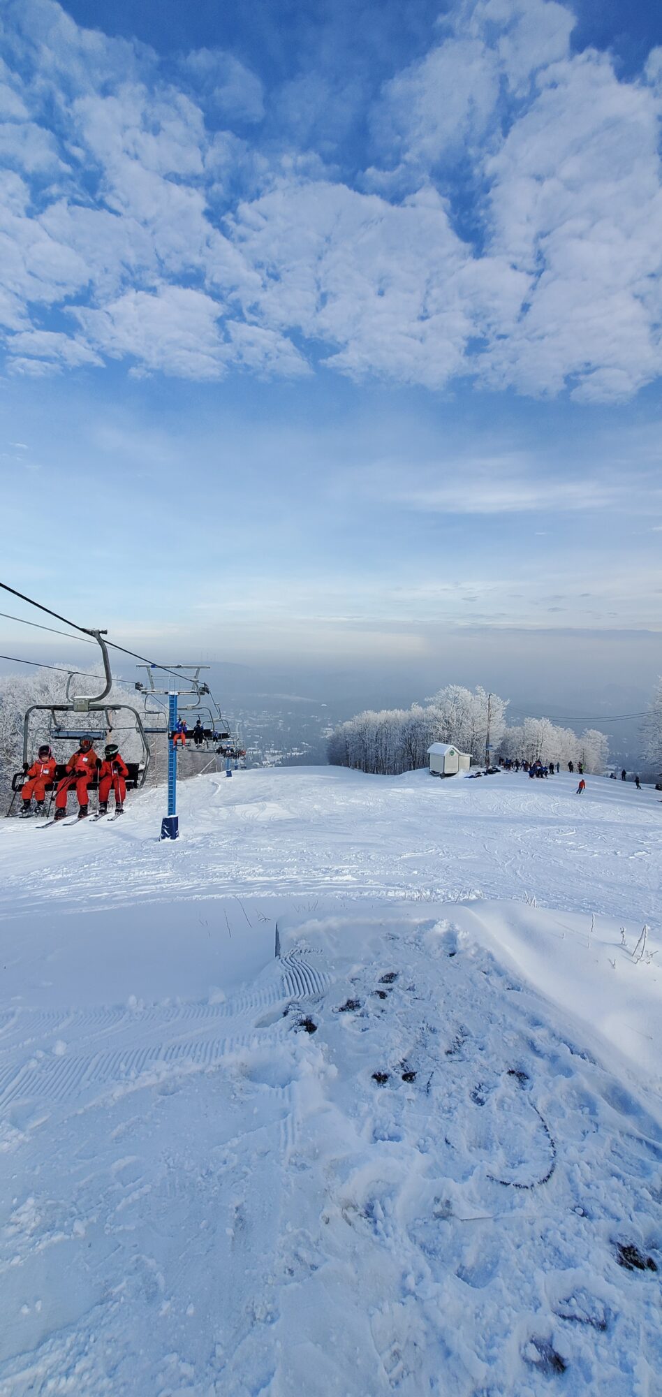 Winter sports scene at Ski Chantecler in Quebec, showing a ski lift ascending toward a challet, framed by a stunning snowy landscape, embodying the charm of this ski resort.