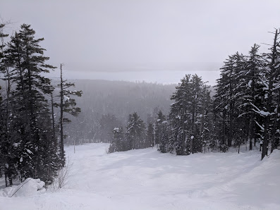 A picturesque winter sports scene at Mt Bohemia in Mohawk Michigan featuring a ski resort snow-covered slopes