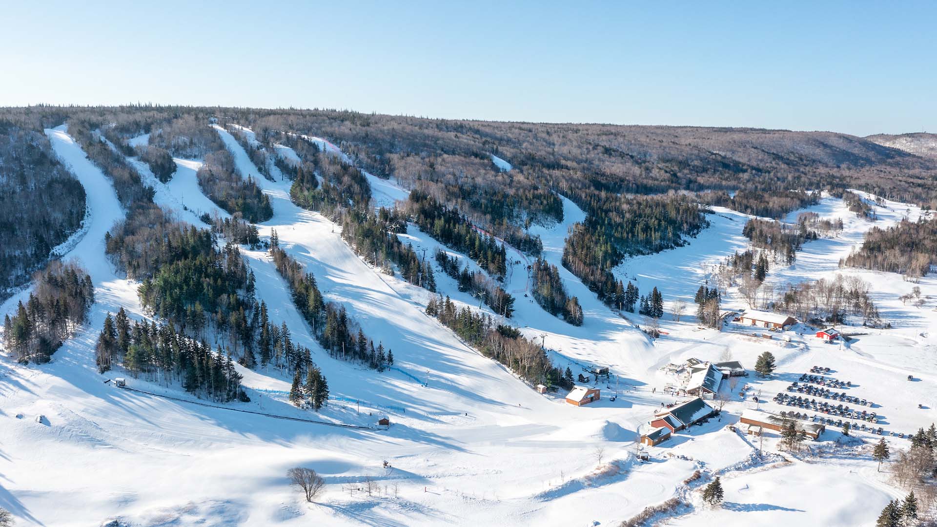 View of Ben Eoin Ski Resort in Nova Scotia, featuring a ski lift and snow-covered slopes bustling with winter sports enthusiasts. The scene exudes a captivating winter charm.
