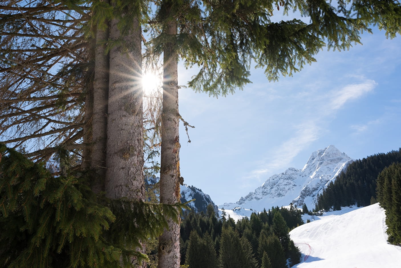 Winter sports scene at Chapelle d'Abondance in France, with a chalet in the background. Skiers enjoying a sunny day against a picturesque winter scenery.