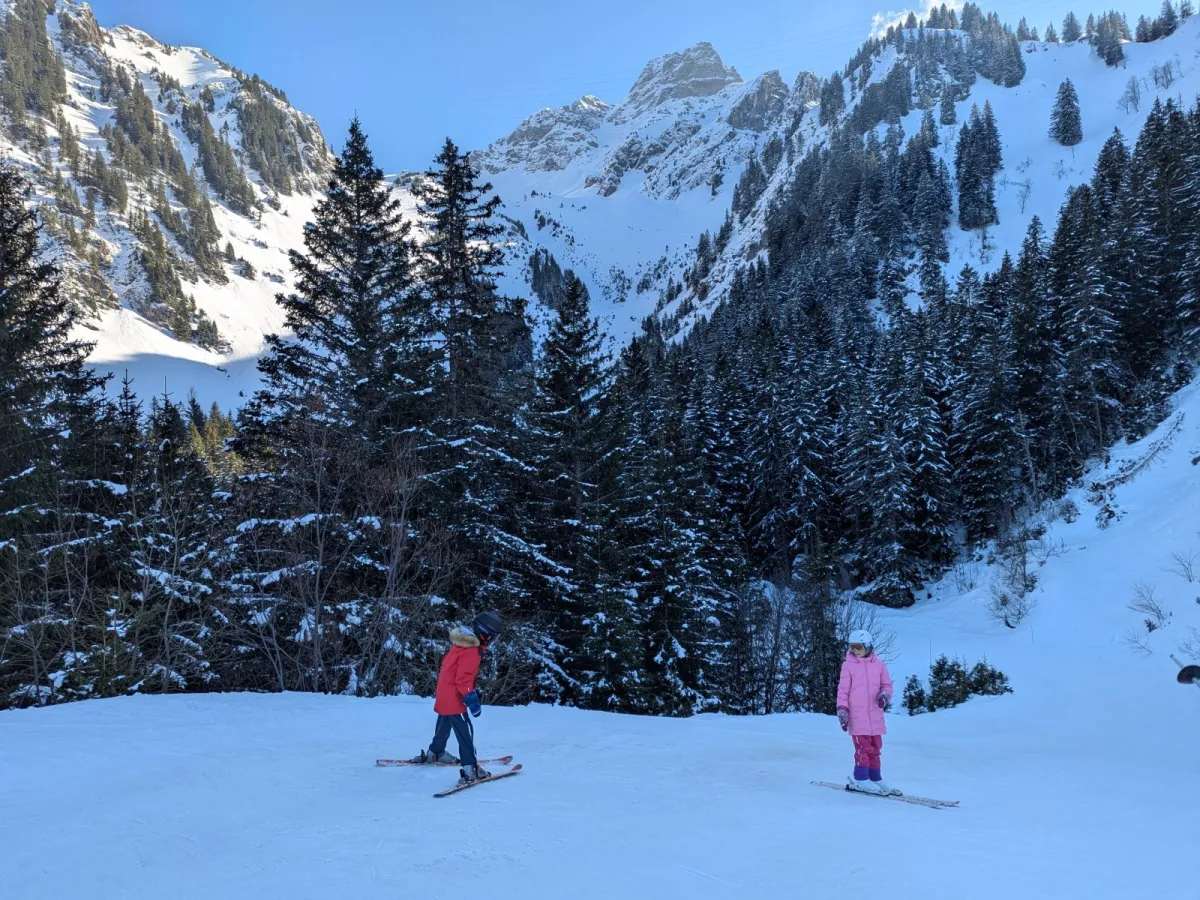 Chapelle d'Abondance in France - two people skiing down a snow covered mountain.