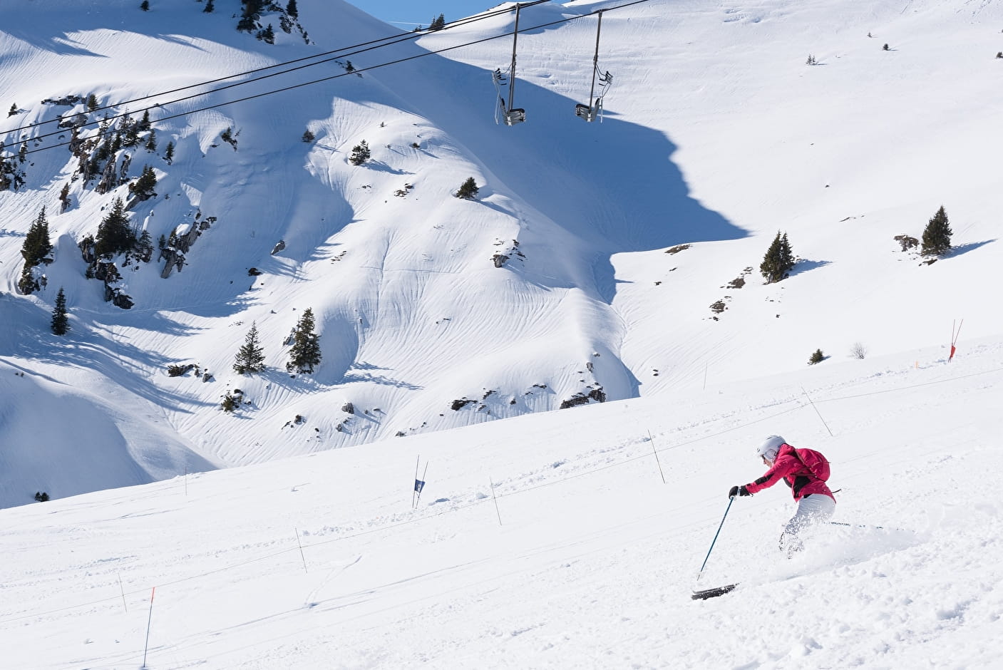 A skier enjoying a winter day at Chapelle d'Abondance in France, with a charming chalet in the background amid the snowy landscape of the ski resort.