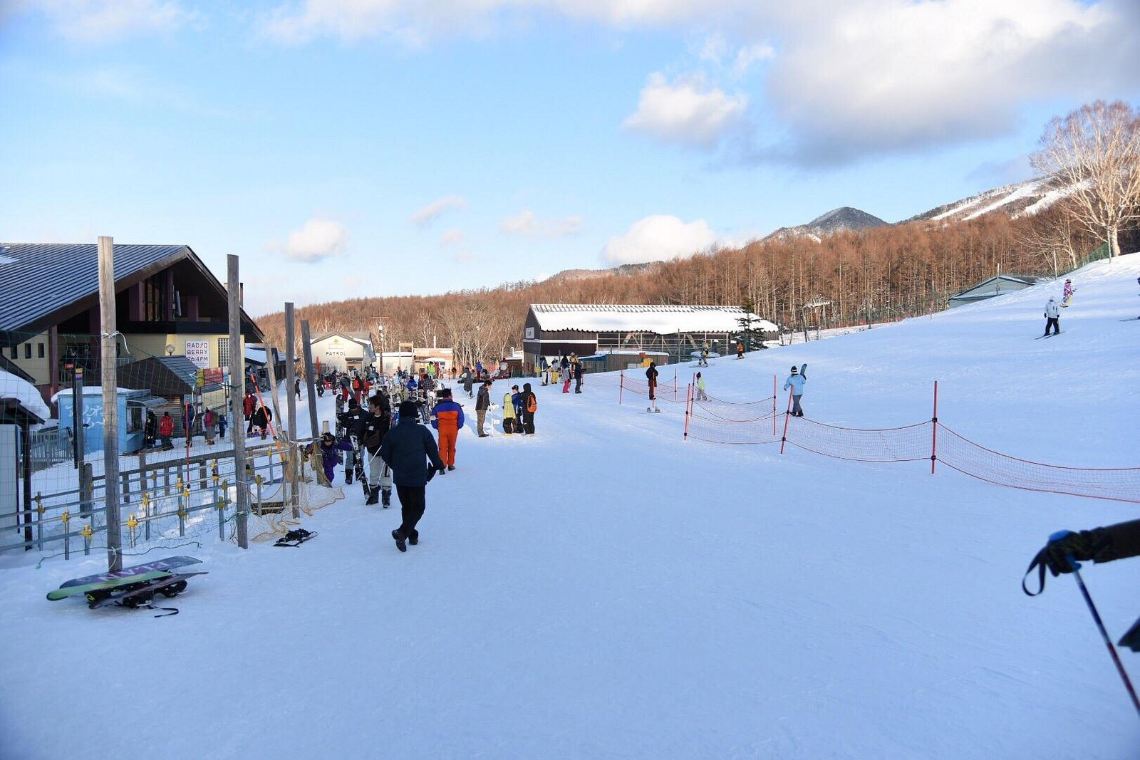 View of Edelweiss ski resort in Kantō, Japan showcasing a vibrant winter sports scene amidst stunning snowy scenery, featuring the resort center and a charming chalet.