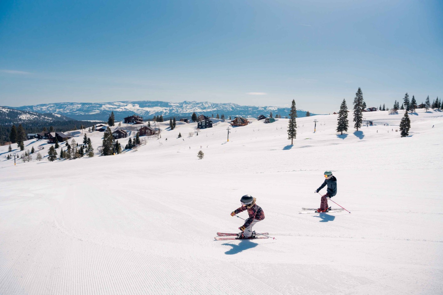 Tahoe Donner in USA - two people skiing down a snow covered mountain.
