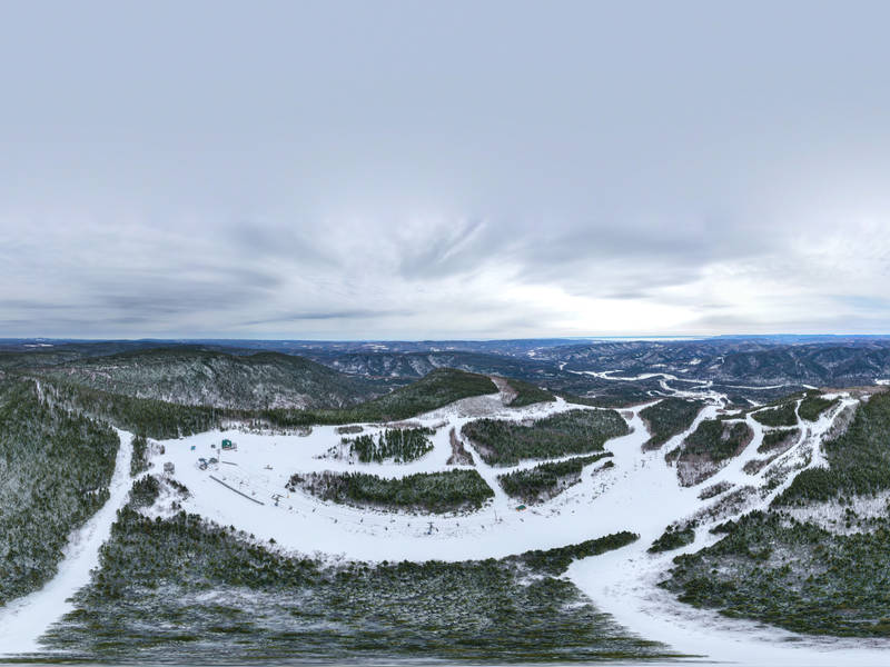 Winter sports scene at Pin Rouge in Quebec, Canada, featuring stunning winter scenery with a ski resort and a chalet.