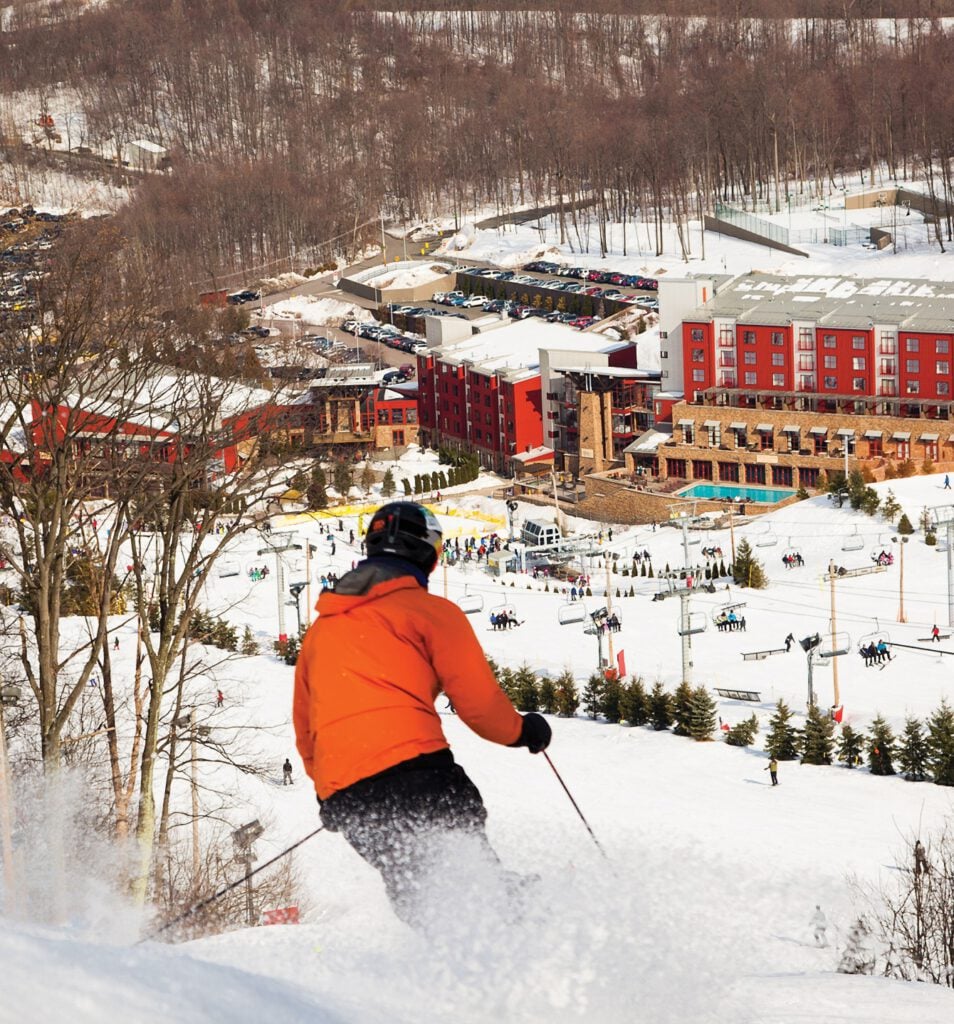 Bear Creek Mountain Resort in USA - a man in an orange jacket skiing down a hill.