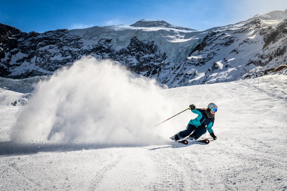 A skier enjoying a winter sports scene at Heidbodme – Saas-Almagell in Valais Switzerland possibly joined by other skiers and a snowboarder at this picturesque ski resort.