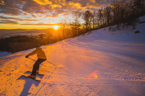 A snowboarder making their way down the wintry slopes at Massanutten, Virginia, showcasing winter sports in action amidst the breathtaking mountain scenery.
