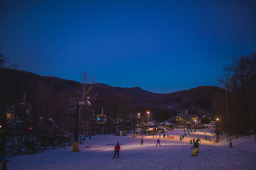 A lively winter sports scene at the Massanutten ski resort in Virginia, USA, featuring pristine snowy landscapes, ski trails, and a ski lift.