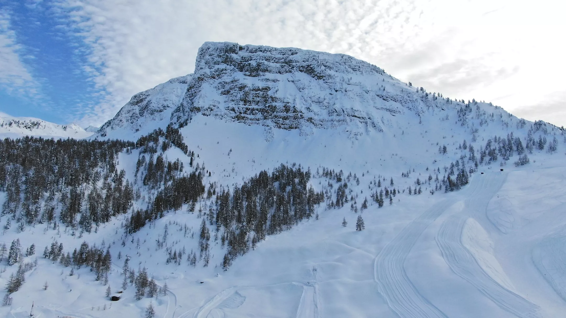 A scenic view from Gerlosstein Austria showcasing a mountain with a ski resort. Winter sports enthusiasts including skiers can be seen enjoying the pristine slopes. A quaint chalet adds to the idyllic winter backdrop.