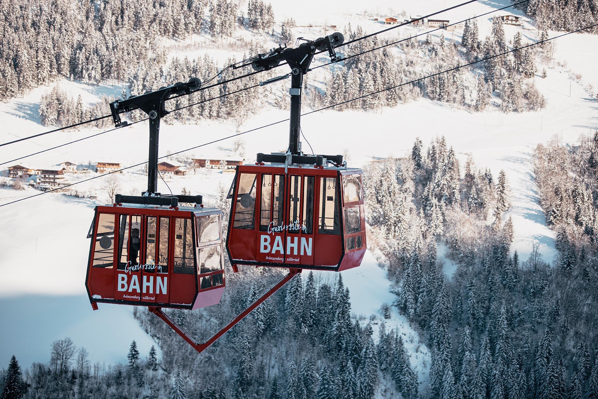 Ski lift operating across snow-covered slopes at Gerlosstein ski resort in Hainzenberg, Tyrol, Austria. A skier enjoys the winter sports scene.