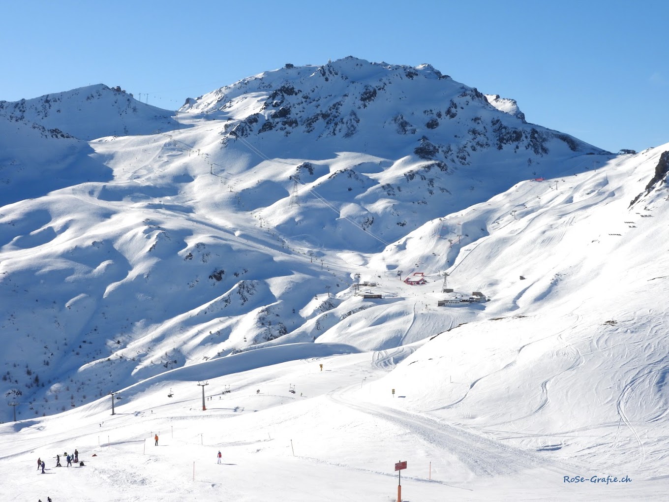 A charming chalet sits nestled in the snowy landscape of Parsenn ski resort in Davos Switzerland embodying the essence of winter sporting life with pristine slopes in the background.
