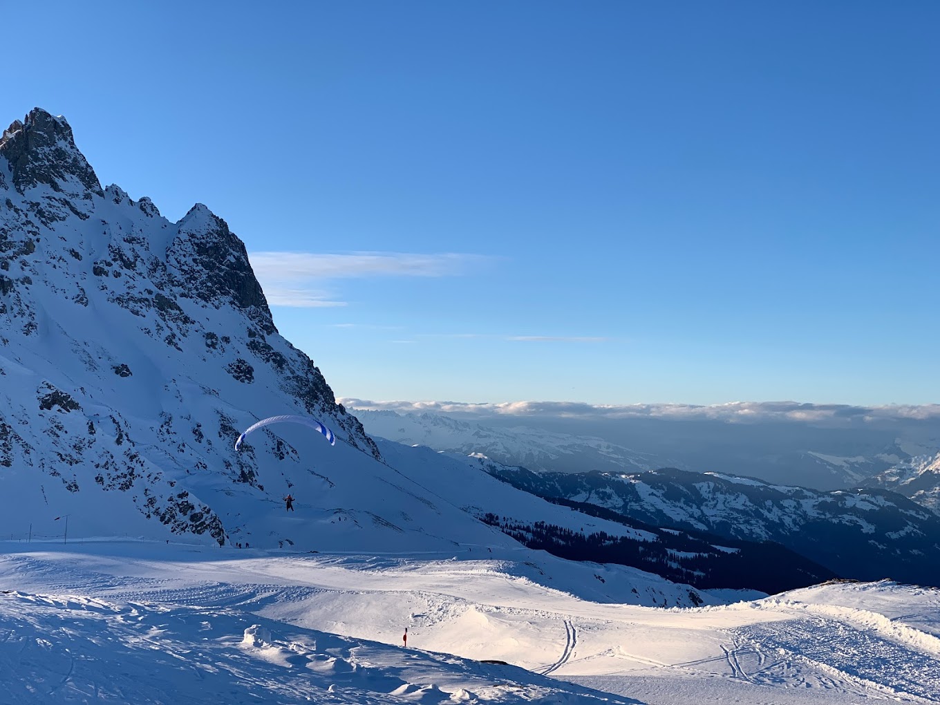 View of the wintery scenic beauty in Parsenn Switzerland where a skier glides past the charming chalet mountains blanketed in snow serve as a stunning backdrop.