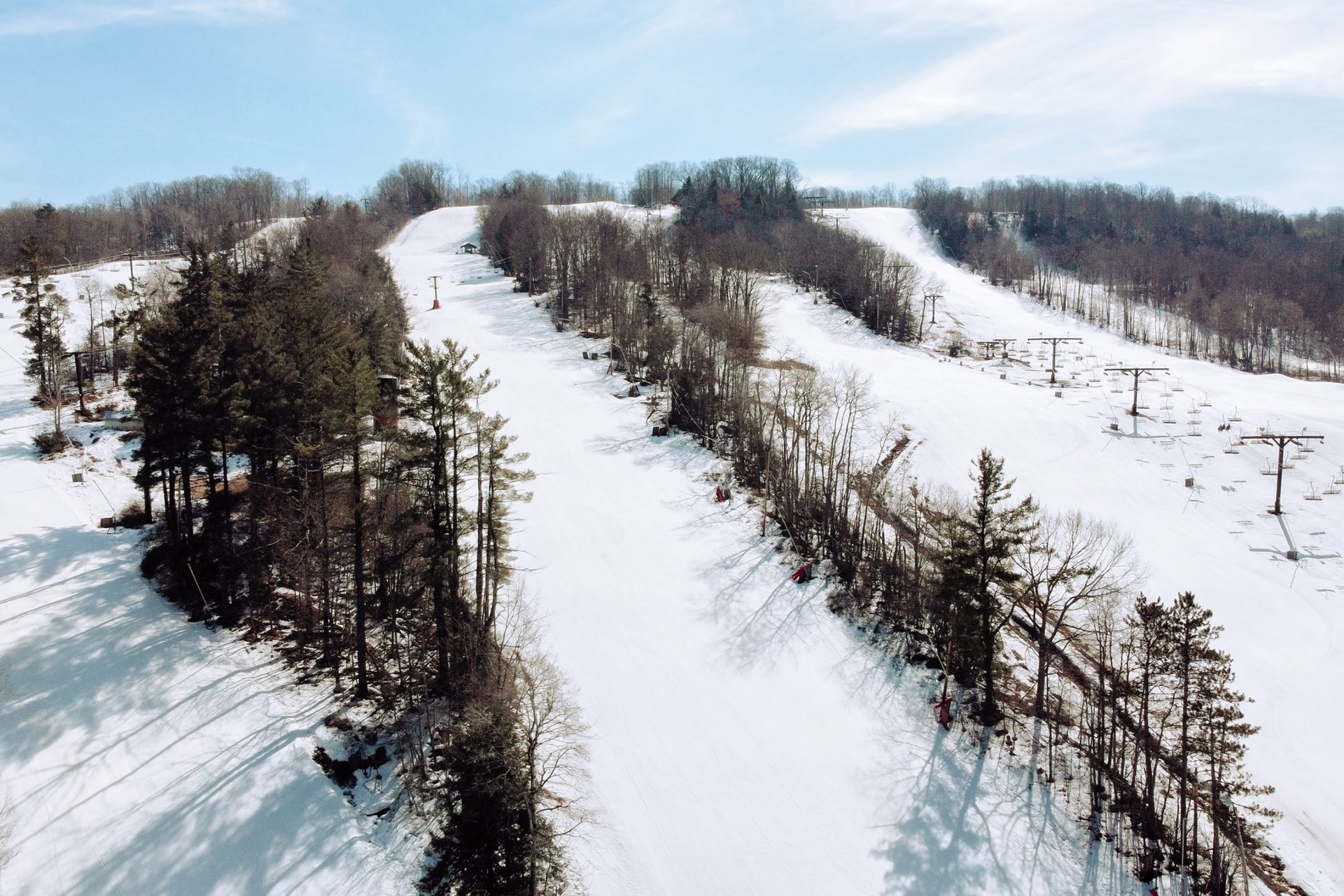 Winter sports scene at Swain Ski Resort in New York, featuring snow-covered slopes, a ski lift, and stunning winter scenery.