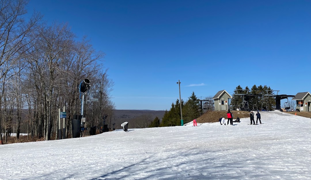 A picturesque view of Jack Frost Mountain ski resort in Pennsylvania USA. Winter sports enthusiasts can be seen skiing down the snowy slopes making use of the ski lift and enjoying the amenities of a charming challet.