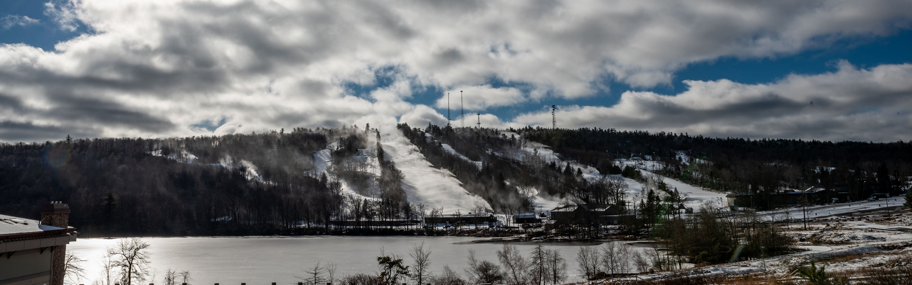 Jack Frost Mountain in USA - a snow covered mountain with a lake in the fore.