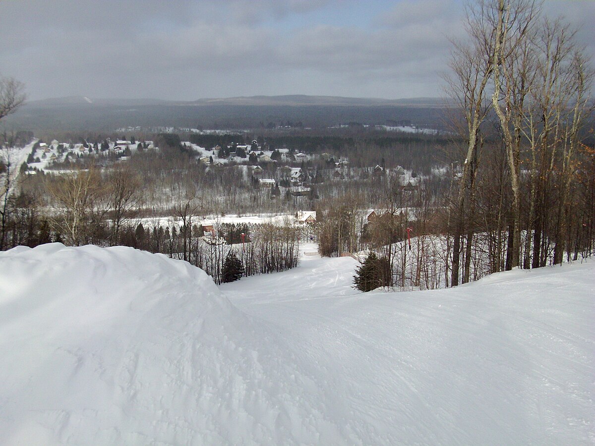 Big Powderhorn Mountain in USA - a person on a snowboard going down a hill.