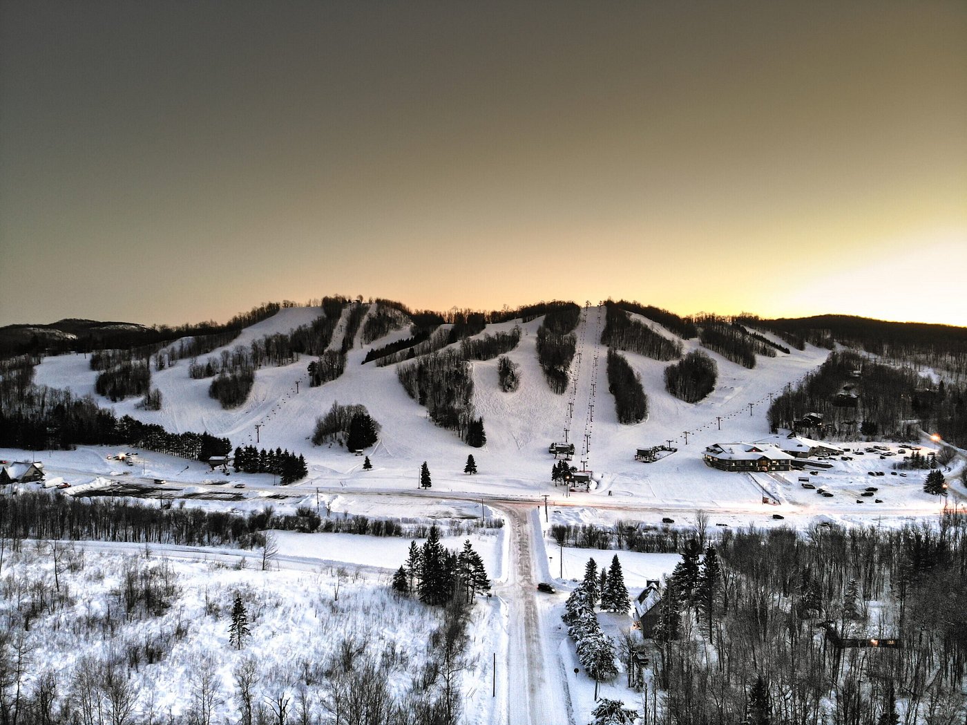Big Powderhorn Mountain ski resort in Bessemer, Michigan featuring skiers enjoying winter sports. A ski lift operates amidst stunning winter scenery.