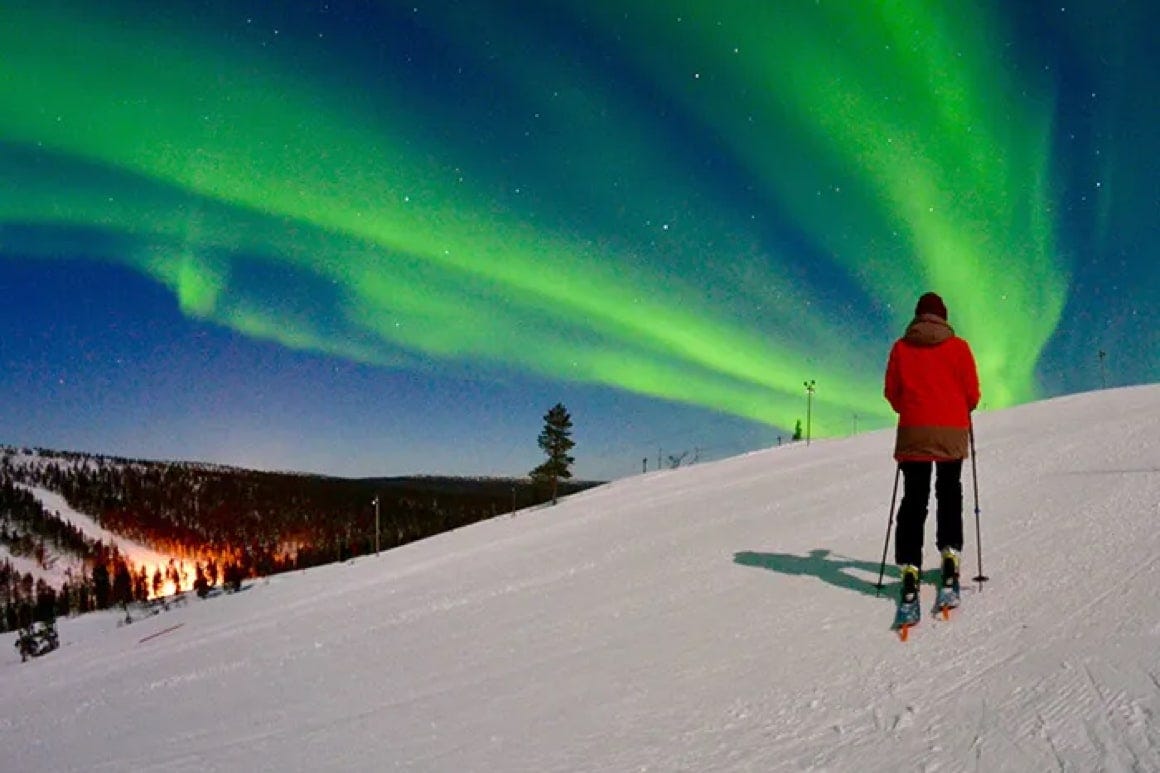 Saariselkä in Finland - a person standing on top of a snow covered hill.