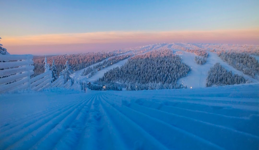 View of Saariselkä in Lapland, featuring a bustling ski resort amidst a beautiful winter landscape, complete with snow-capped trees and bright white slopes ideal for winter sports.