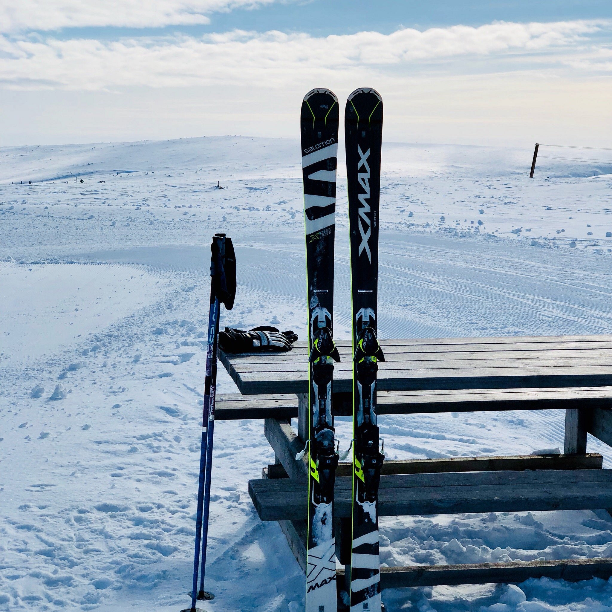 Winter sports scene at Saariselkä, Lapland, featuring a skier in motion downhill. A ski lift can be seen in the background at the ski resort.
