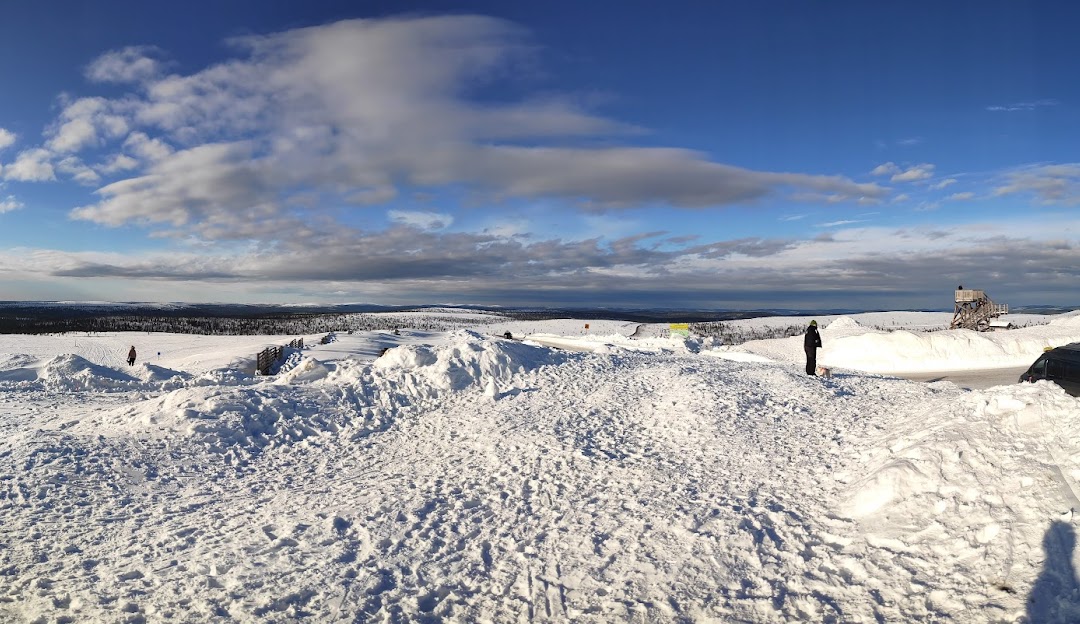 A winter sports scene in Saariselkä, Lapland, featuring stunning winter scenery with ski runs in the background, as well as a cozy chalet nestled in the snow-covered landscape.