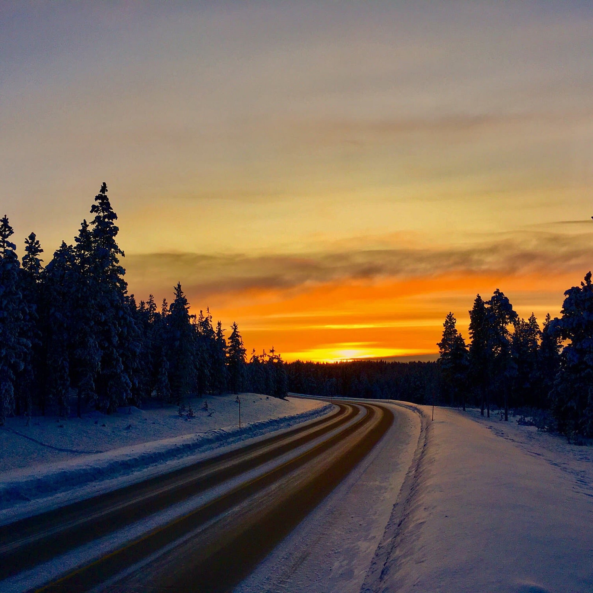 Winter scene in Saariselkä, Lapland showing pristine snow-covered surroundings, with a glimpse of a chalet and a snowmobile. A serene environment perfect for winter sports.