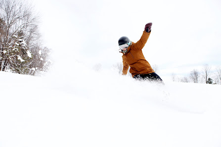 A skier and a snowboarder enjoying a day on the slopes at Saskadena Six in South Pomfret, Vermont, creating a lively winter sports scene.