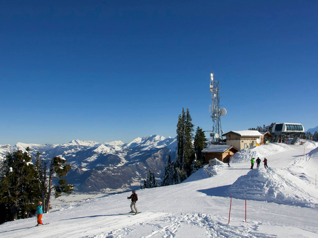 Winter sports scene at La Sambuy-Seythenex in France, featuring a bustling ski resort with a ski lift and skiers enjoying the snowy slopes.