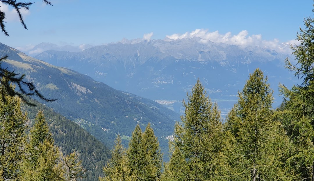Charming chalet situated amidst the picturesque scenery of Pescegallo Valgerola in Valtellina, Lombardy, Italy. The surrounding majestic mountains under the blue sky hint at a popular ski resort.