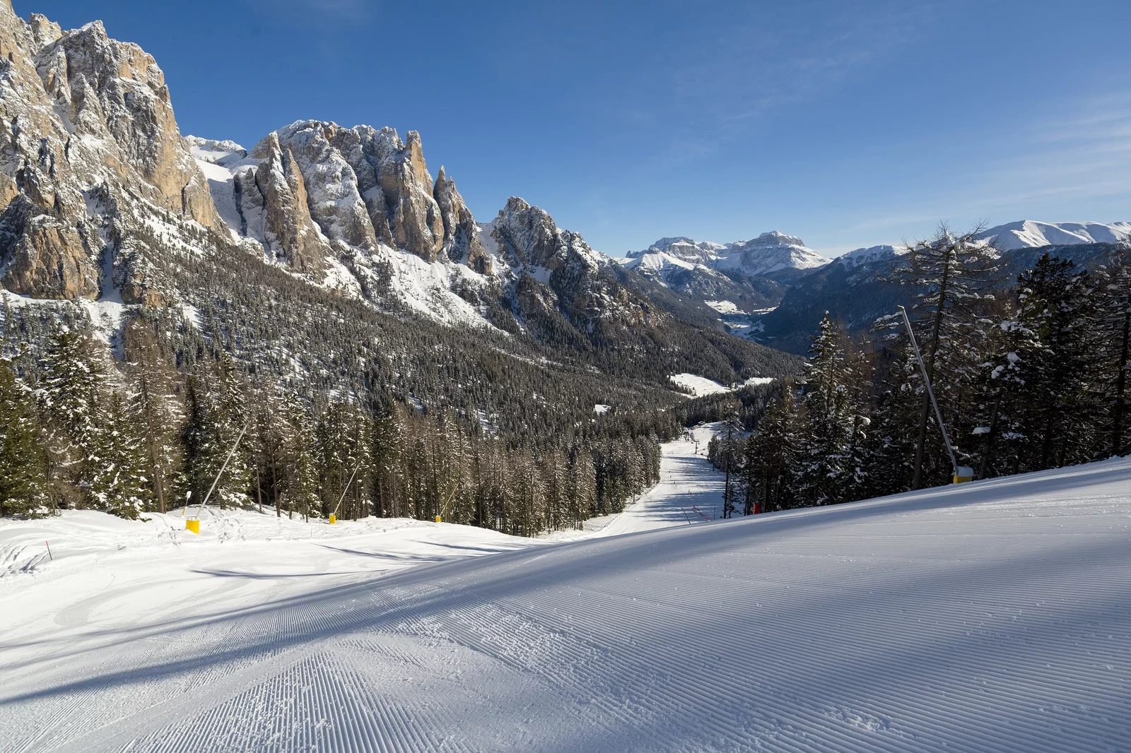 Val di Fassa ski in Italy - a person skiing down a snowy slope in the mountains.