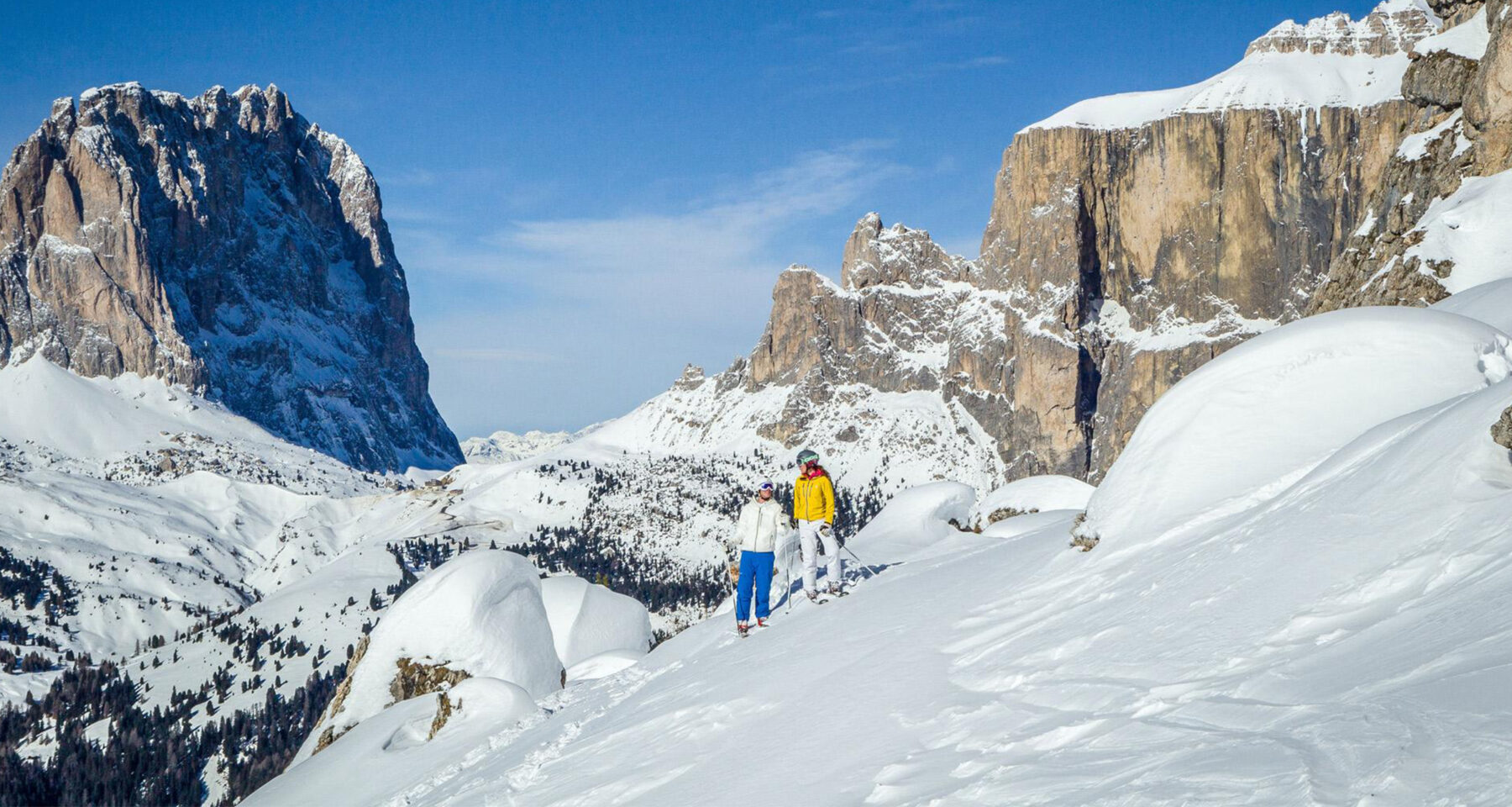 Val di Fassa ski in Italy - a group of people skiing down a snowy mountain.