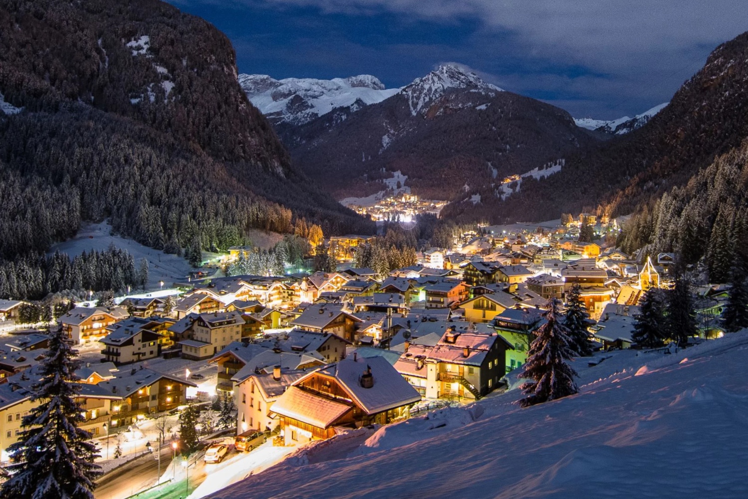 Val di Fassa ski in Italy - a snowy village in the mountains at night.