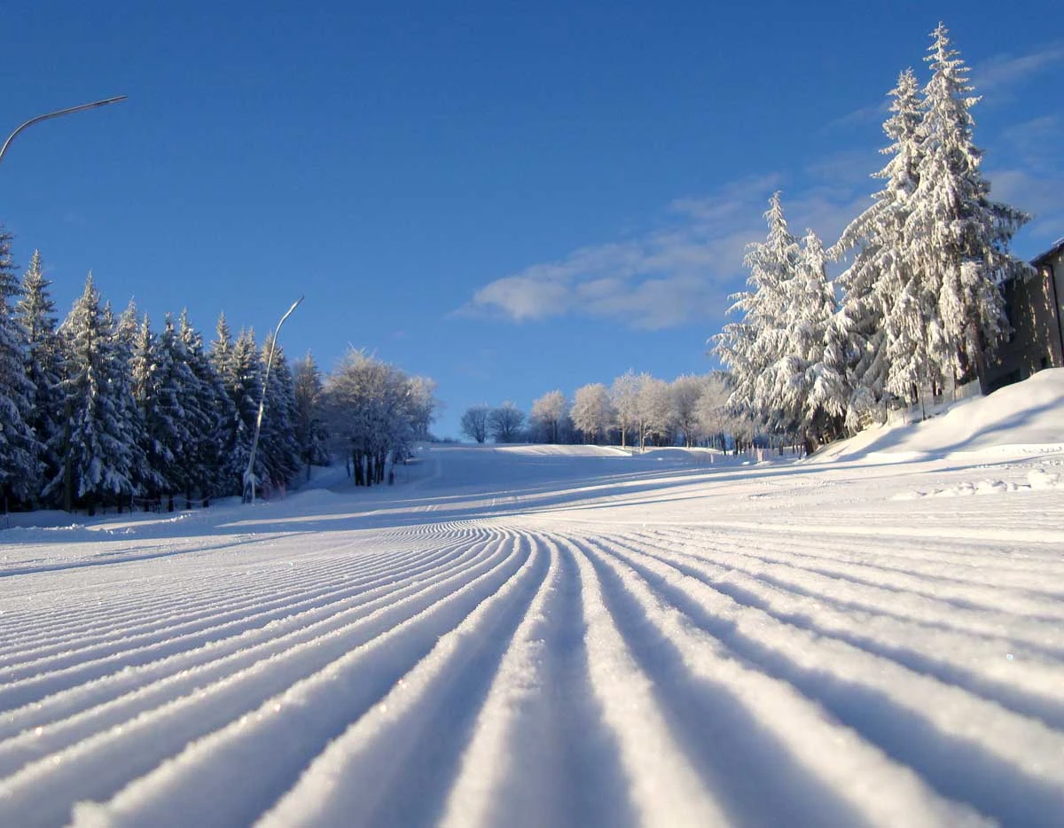 Schia – Monte Caio in Italy - a snow covered road with trees in the background.