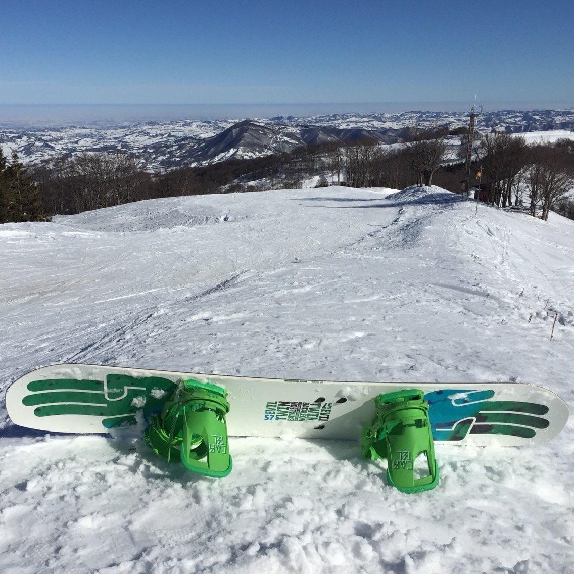 Skier gliding down snow-covered slopes at the Schia – Monte Caio ski resort in Parma, Italy, with a charming chalet nestled in the winter landscape.