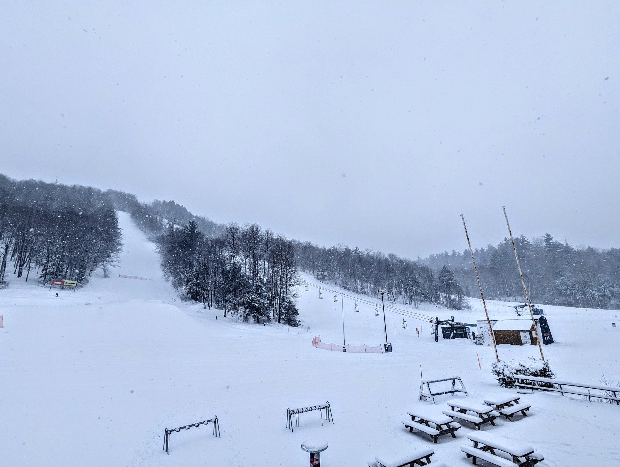 A picturesque view of Whaleback ski resort in Enfield, New Hampshire, showcasing a stunning winter landscape and sports activities, with a chalet in the distance.