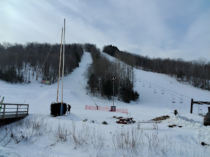 A winter sports scene at Whaleback in Enfield New Hampshire. Skiers are seen utilizing a ski lift to ascend the mountain at this bustling ski resort ready to glide down the snowy slopes.