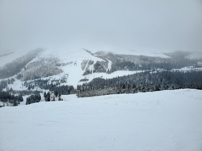Scenic image of Magic Mountain Resort in Kimberly Idaho showcasing a bustling winter sports scene on its snow-covered slopes. The imposing mountain and serene winter scenery enhance the beauty of this popular ski resort.