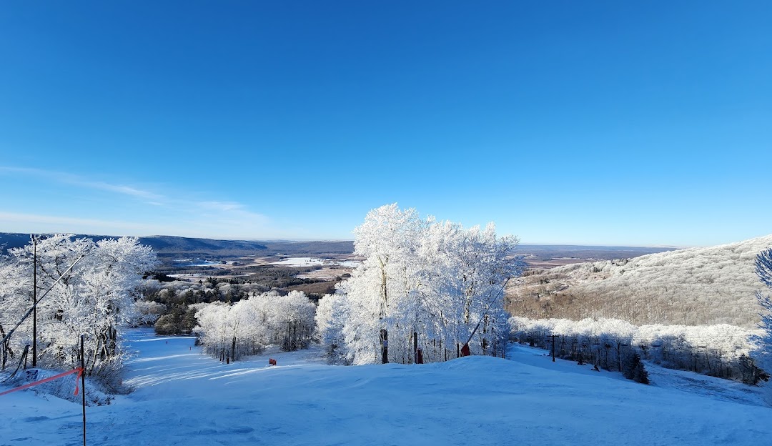 Winter wonderland at Canaan Valley, Davis, West Virginia, featuring snowy slopes bustling with winter sports activities, against the backdrop of a quaint challet and a beautiful ski resort.