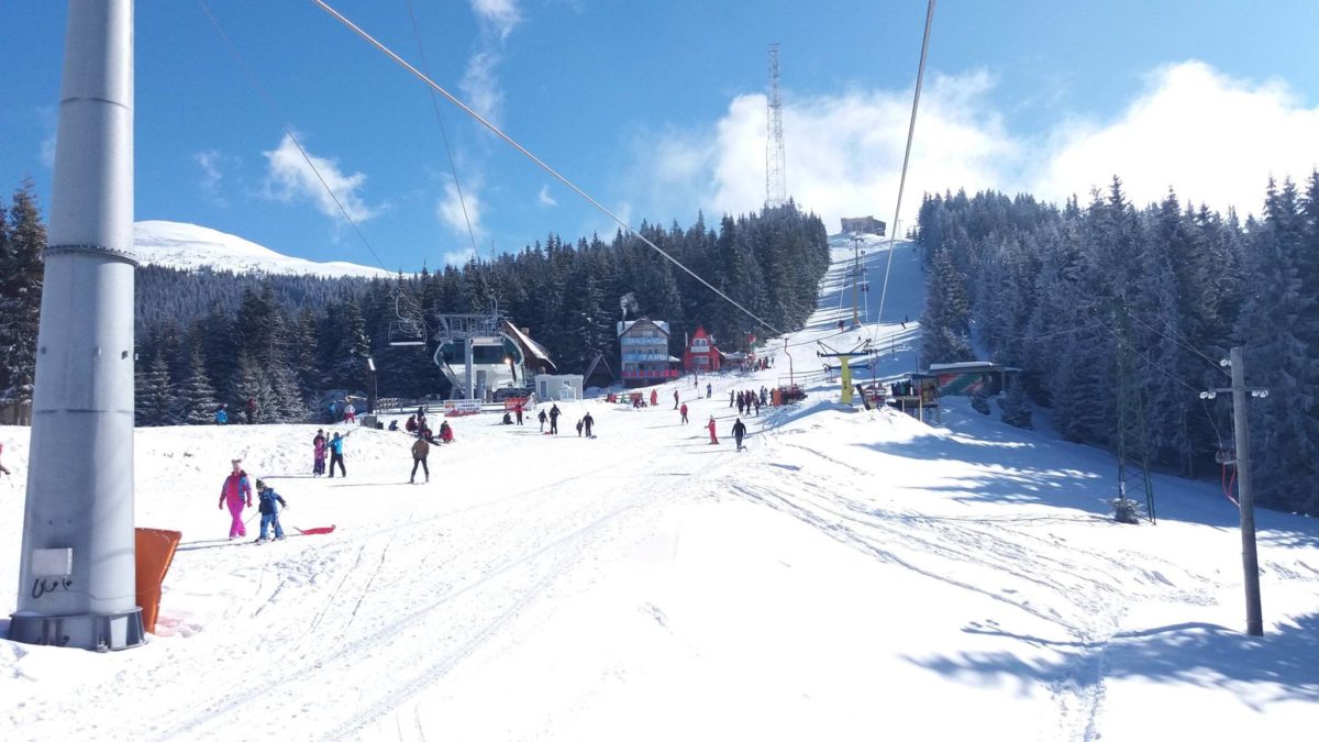 Parâng in Romania - a ski slope with people skiing down it.