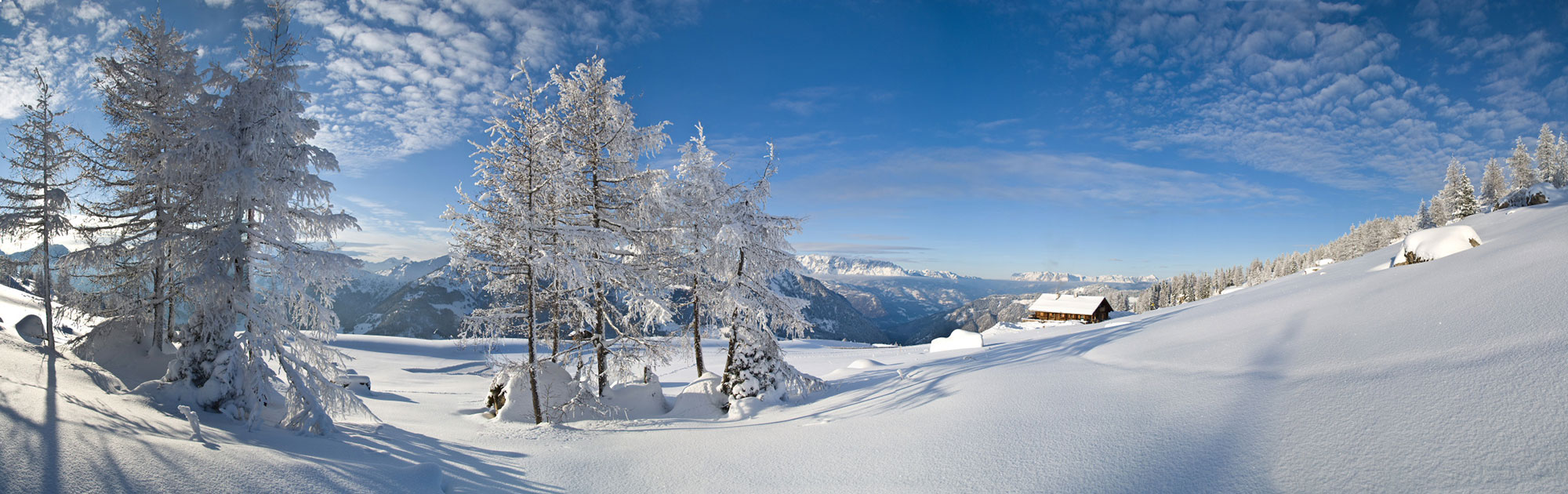 Winter scene in Großarltal, Dorfgastein, Austria showing a picturesque snow-filled landscape with winter sports activity happening near a cozy mountain challet.