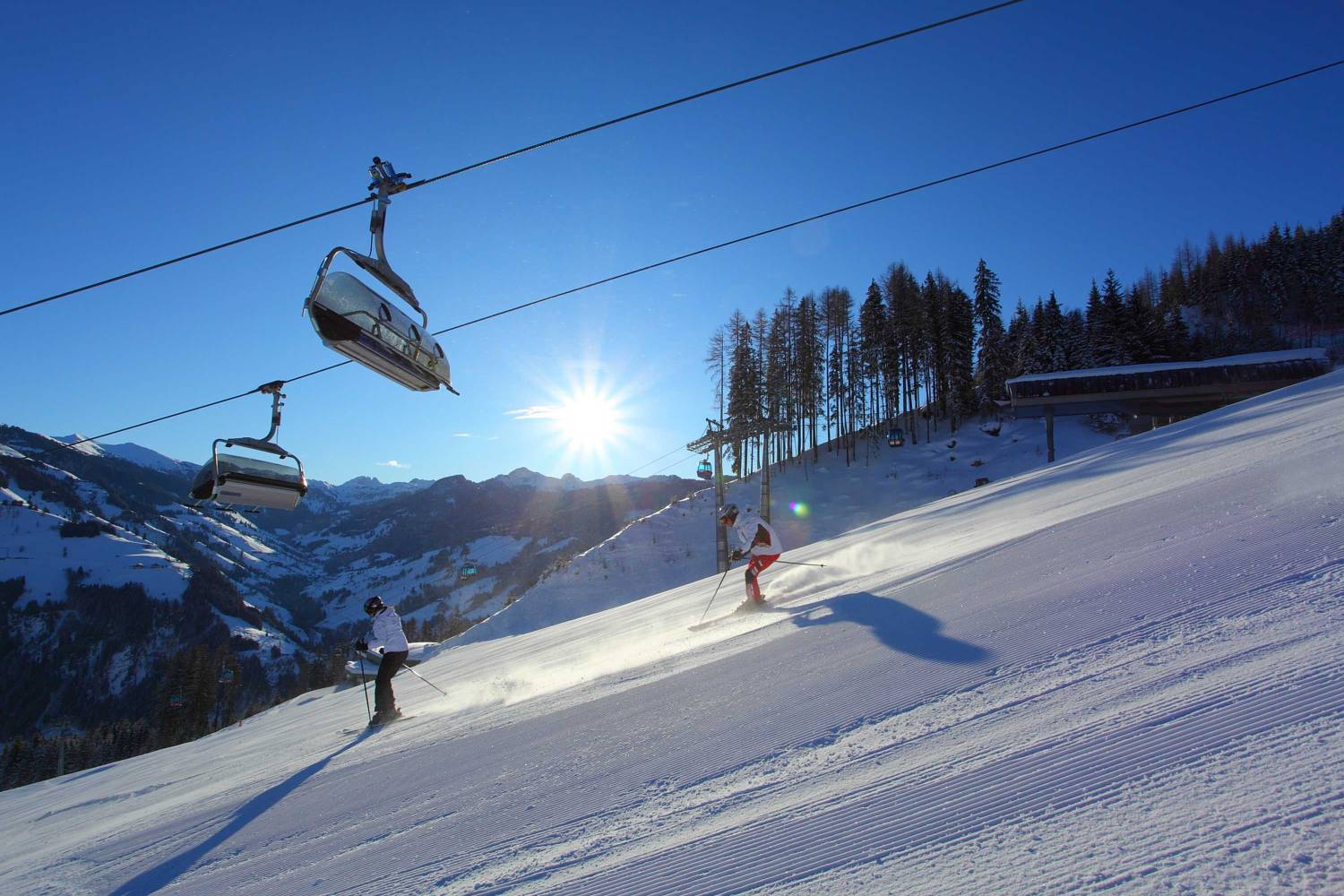 Großarltal | Dorfgastein in Austria - two people are skiing down a snowy slope.